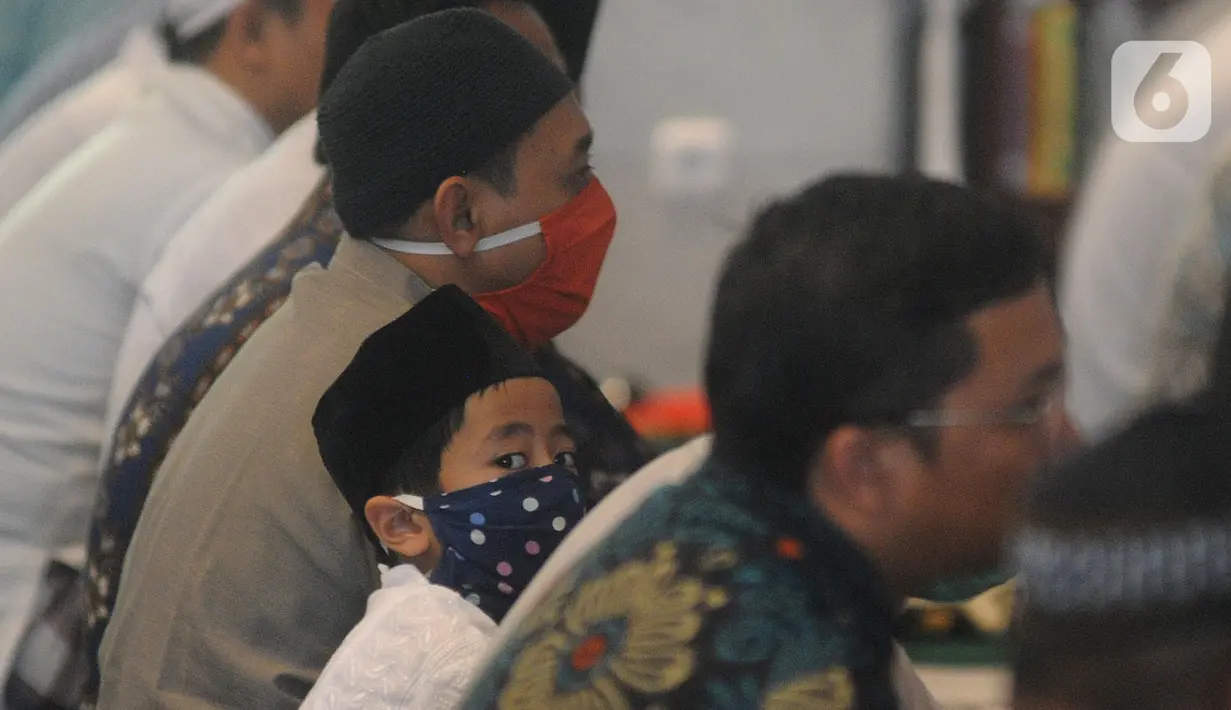 Seorang anak mengenakan masker saat dirinya mengikuti salat Jumat di Masjid Raya Cinere, Depok, Jumat (20/3/2020). Masjid Raya Cinere tetap menggelar salat Jumat di tengah penyebaran virus corona, meski begitu jemaah diimbau tetap menjaga kesehatan. (merdeka.com/Arie Basuki)