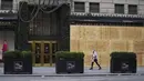 <p>Seorang perempuan melewati Saks Fifth Avenue yang dipasangi papan pelindung di Fifth Avenue di New York, Amerika Serikat pada 1 November 2020. Langkah itu dilakukan saat para peretail berupaya melindungi properti dari penjarahan atau kerusuhan lainnya dalam beberapa hari mendatang (Xinhua/Wang Ying)</p>