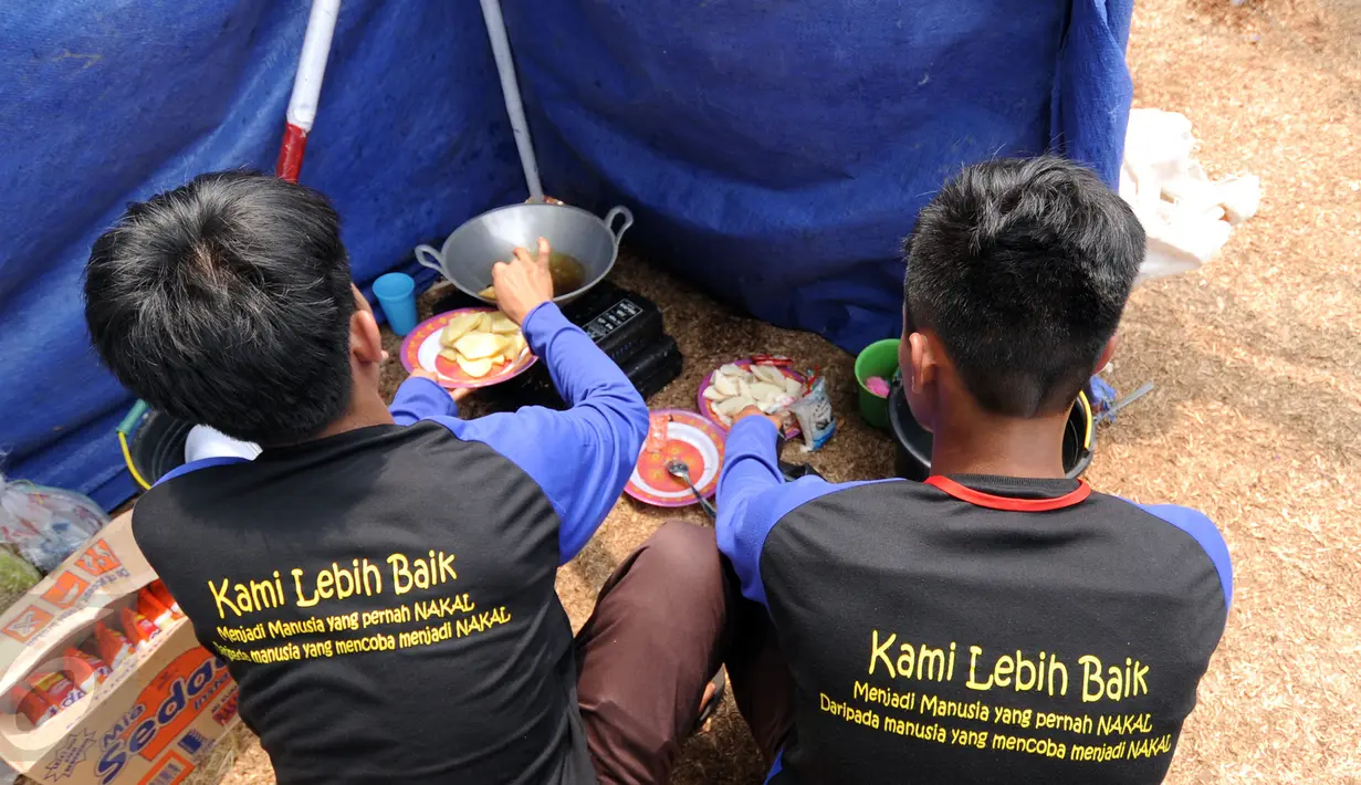 Dua anggota pramuka dari Gugus Depan Warga Binaan memasak makanan saat mengikuti Perkemahan Pemasyarakatan se-Jawa dan Lampung 2015 di Buperta Cibubur Jakarta, Rabu (26/8/2015). (Liputan6.com/Helmi Fithriansyah)