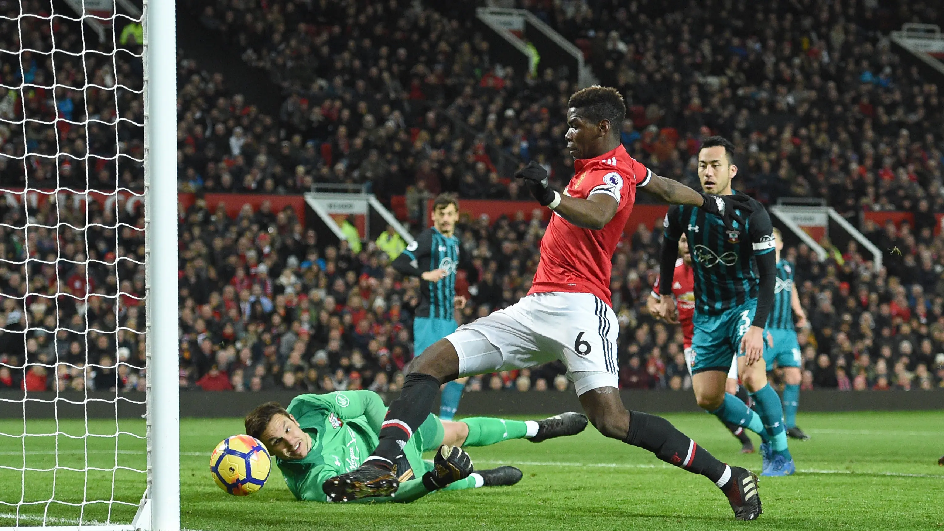 Aksi pemain Manchester United, Paul Pogba mencoba melewati adangan kiper Southampton pada lanjutan Premier League di Old Trafford, Manchester, (30/12/2017). MU hanya bermain imbang 0-0. (AFP/Oli Scarff)