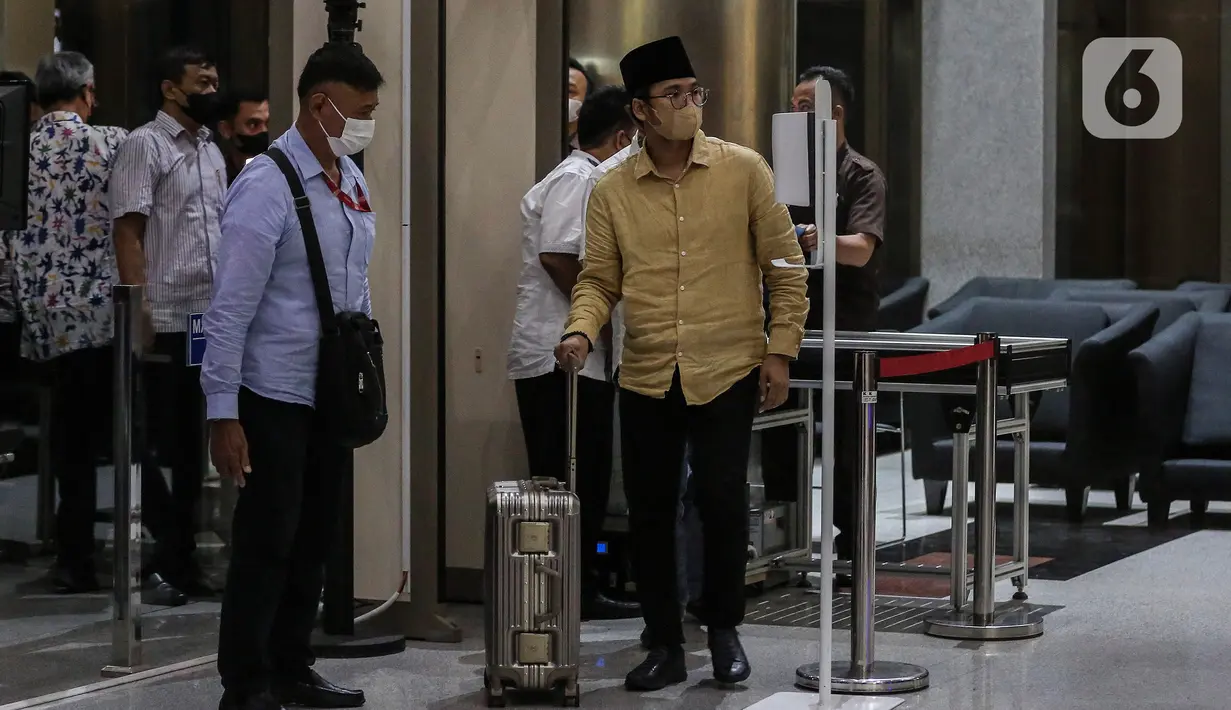 Bupati Bangkalan Abdul Latif Amin Imron membawa koper dan dikawal saat tiba di Gedung Komisi Pemberantasan Korupsi (KPK), Jakarta, Rabu (7/12/2022). KPK menangkap Bupati Bangkalan Abdul Latif Amin Imron sebagai tersangka kasus suap lelang jabatan di Pemerintahan Kabupaten Bangkalan, Jawa Timur. Total kekayaan yang dimiliki Abdul Latif sebanyak Rp 9,9 miliar. (Liputan6.com/Johan Tallo)