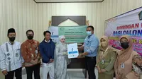 Secara simbolis managemen PT Interport memberikan buku panduan kepada calon pengantin untuk bekal dalam berumah tangga demi menciptakan generasi yang berkualitas. (Liputan6.com/Apriyanto)