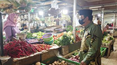 Kepala UPT Pasar Cisalak, Muhammad Sahal meninjau harga kebutuhan pokok di sejumlah pedagang. (Liputan6.com/Dicky Agung Prihanto)