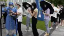 Para pekerja yang mengenakan masker berbaris untuk tes COVID-19 di Beijing, China, 12 Juli 2022. Beijing telah membatalkan rencana untuk mengizinkan hanya orang yang divaksinasi yang memasuki ruang publik. (AP Photo/Ng Han Guan)