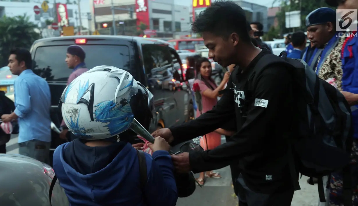 Aktifis GAMKI memberikan bunga dan takjil kepada pengguna jalan saat memperingati hari lahir Pancasila,  Jakarta, Rabu (30/5). Pemberian takjil ini sebagai bentuk menjaga empat pilar kebangsaan yang digaungkan MPR RI. (Liputan6.com/Johan Tallo)
