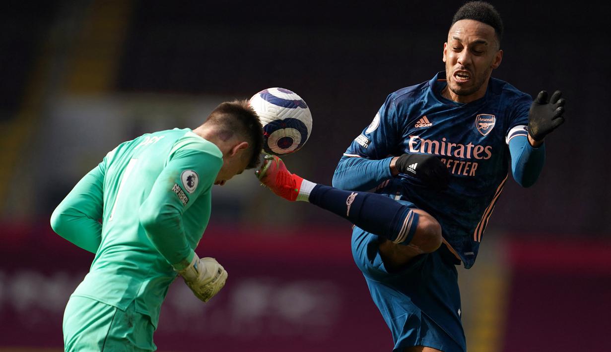 Penyerang Arsenal, Pierre-Emerick Aubameyang (kanan) berebut bola dengan kiper Burnley, Nick Pope dalam pertandingan lanjutan Liga Inggris. (Foto: AFP/Pool/Jon Super)