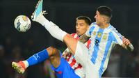 Gelandang Paraguay Diego Gomez (kiri) dan gelandang Argentina Enzo Fernandez berebut bola selama pertandingan kualifikasi Piala Dunia FIFA 2026 Amerika Selatan antara Paraguay dan Argentina di stadion Ueno Defensores del Chaco di Asuncion pada 14 November 2024.Daniel Duarte / AFP