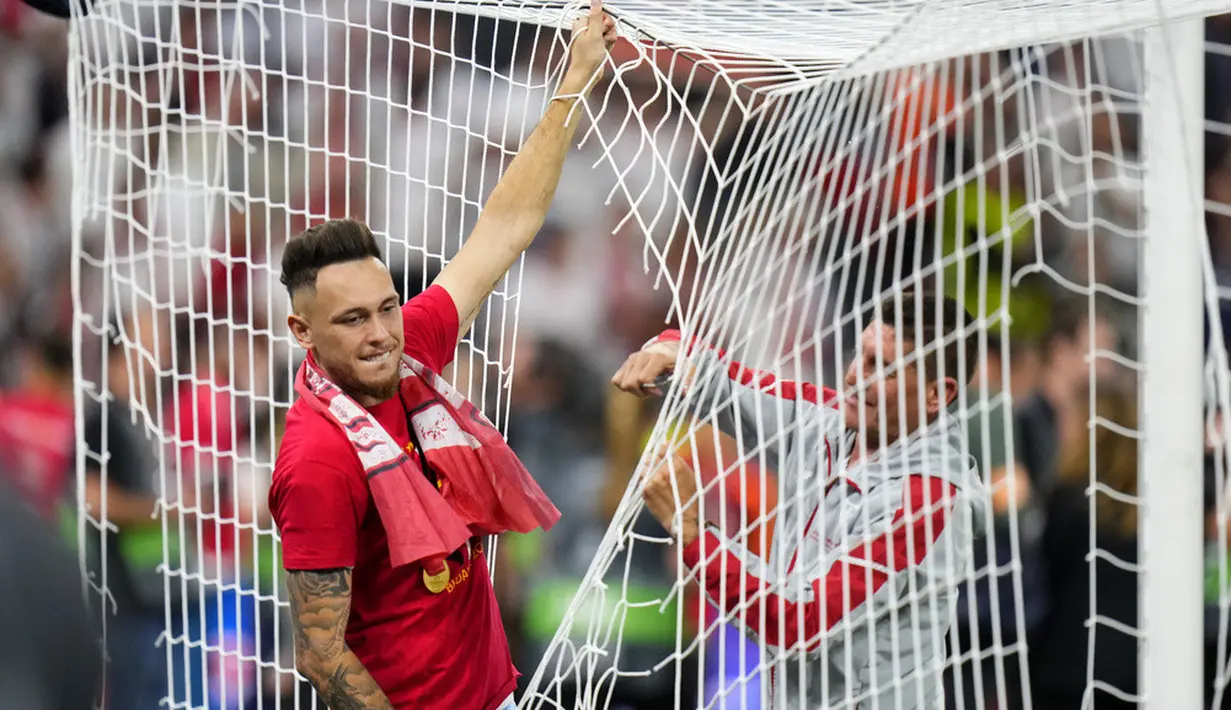 <p>Pemain Sevilla Lucas Ocampos memotong jaring gawang setelah memenangkan pertandingan sepak bola final Liga Europa antara Sevilla dan AS Roma. (AP Photo/Petr David Josek)</p>