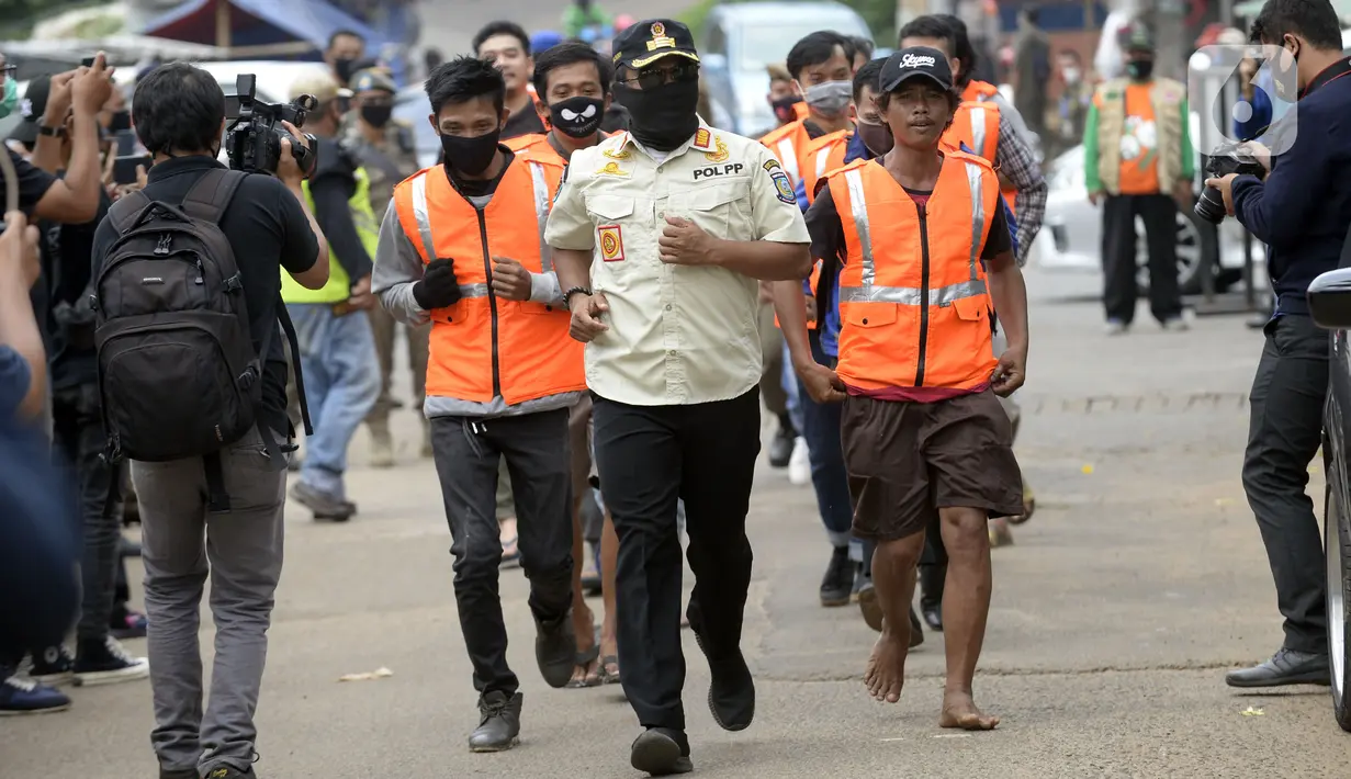 Warga pelanggar PSBB dihukum berlari saat terjaring Operasi Yustisi yang digelar petugas gabungan di BSD, Tangerang Selatan, Banten, Rabu (16/9/2020). Tangerang Selatan sebagai kota penyangga Ibu Kota ikut melakukan pengetatan PSBB karena peningkatan kasus Covid-19. (merdeka.com/Dwi Narwoko)