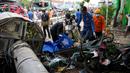 Polisi memasukkan jenazah korban ke dalam kantong jenazah usai kecelakaan lalu lintas di Bekasi, Indonesia, Rabu (31/8/2022). Kecelakaan memakan korban jiwa dan mengakibatkan sejumlah penguna jalan luka-luka. (AP Photo/Achmad Ibrahim)