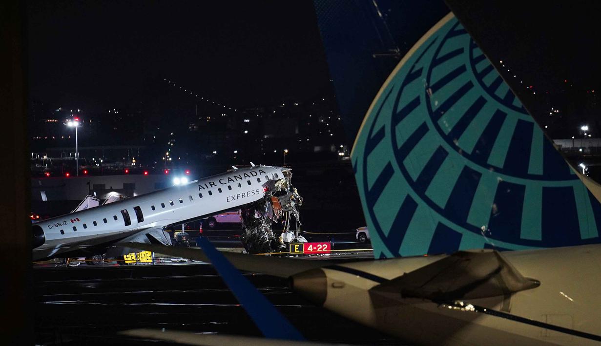 Badan Penerbangan Federal (FAA) Amerika Serikat menyebut, setidaknya penutupan bandara akan berlangsung hingga pukul 14.00 pada Senin (23/3/2026) waktu setempat. Tampak dalam foto, sebuah jet Air Canada Express terparkir di landasan pacu Bandara LaGuardia, New York, Amerika Serikat, Senin 23 Maret 2026, setelah bertabrakan dengan kendaraan Otoritas Pelabuhan. (AP Photo/Ryan Murphy)