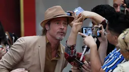 Aktor Brad Pitt berselfie dengan penggemar saat menghadiri acara karpet merah untuk film "Once Upon a Time In Hollywood" di Mexico City (12/8/2019). Film garapan sutrada Quentin Tarantino ini akan diputar di Mexico City pada Agustus 23.  (AP Photo/Marco Ugarte)