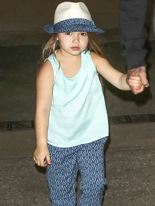 Harper Beckham saat berada di London pada 22 Juni 2015. Harper tampil santai dengan topi yang berwarna senada dengan celananya. (harperbeckhamfashion)