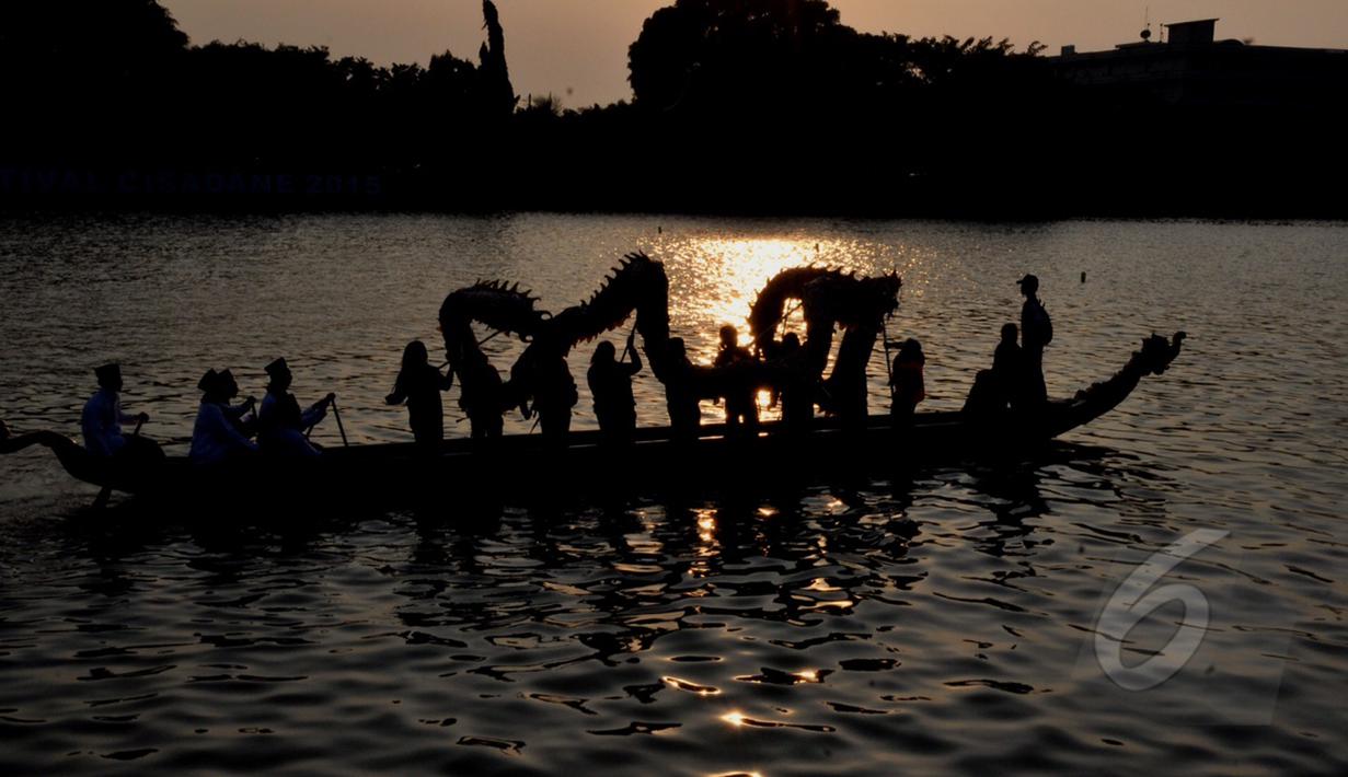 Sejumlah peserta memainkan naga liong saat melintasi Sungai Cisadane dalam rangka Festival Cisadane 2015, Banten, Sabtu (2305/2015). Sebanyak 100 perahu nusantara menampilkan berbagai pernak-pernik budaya khas nusantara (Liputan6.com/Andrian M Tunay)