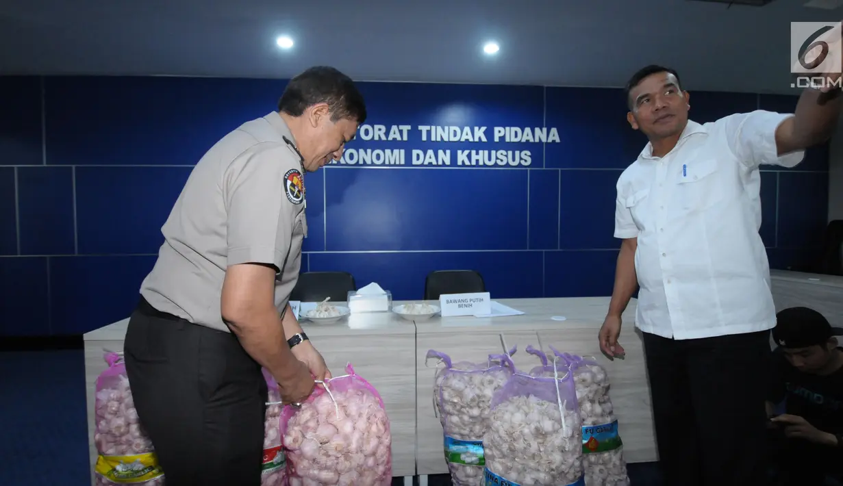 Wadir Tipideksus Polri, Kombes Pol Daniel Tahi Monang Silitonga (kanan) melihat barang bukti jelang rilis penyalahgunaan distribusi bawang putih impor di Jakarta, Kamis (31/5). DirTipideksus mengamankan 30.000 ton. (Liputan6.com/Helmi Fithriansyah)