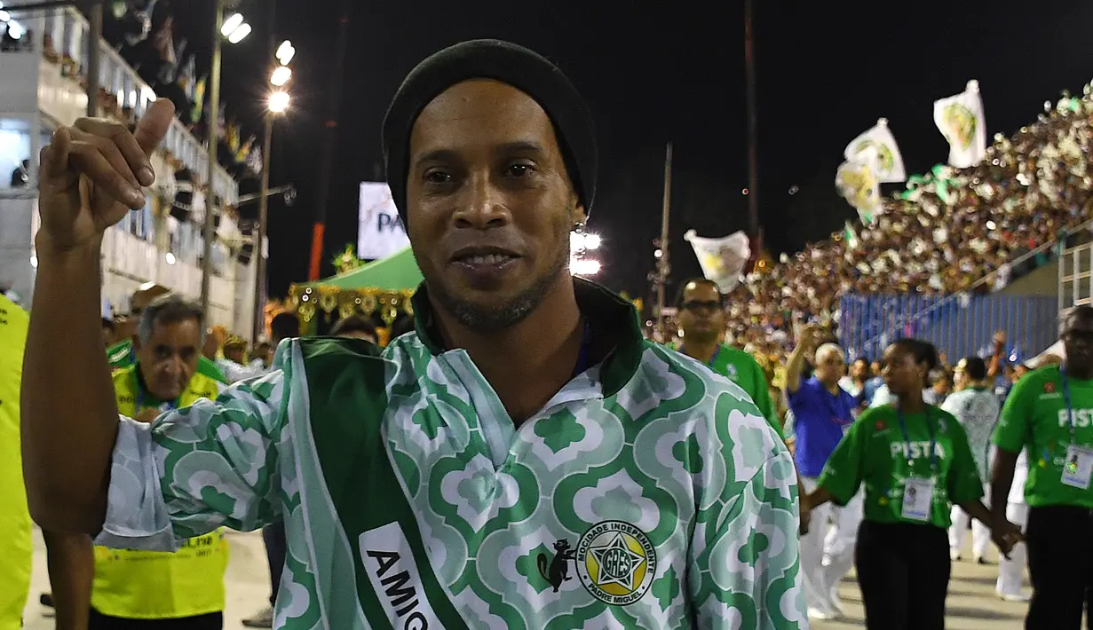 Ronaldinho Gaucho saat menghadiri malam kedua Karnaval Samba di Sambadrome, Rio de Janeiro, Brasil (28/2). Parade karnaval tahunan ini menampilkan aksi para penari-penari seksi dari sejumlah sekolah samba di Brasil. (AFP Photo / Vanderlei Almeida)