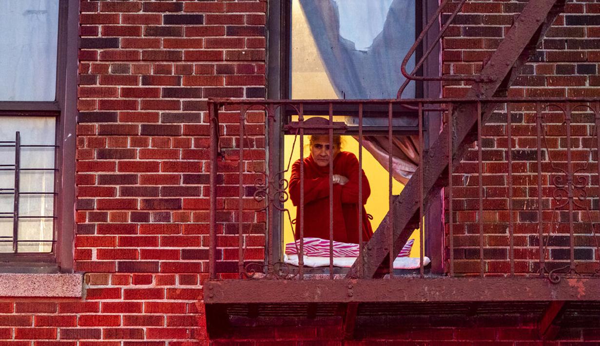 Seorang wanita melihat lokasi kebakaran gedung apartemen dari jendela di Bronx, New York, Amerika Serikat, 9 Januari 2022. Menurut Komisaris FDNY Daniel Nigro, mayoritas korban tewas karena menghirup asap yang parah. (AP Photo/Jeenah Moon)