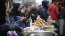 Terlihat upaya warga tetap berupaya menjaga semangat hari kemenangan dengan berbelanja kebutuhan pokok dan persiapan Idul Fitri 1447 Hijriah. Tampak dalam foto, seorang perempuan pengungsi Palestina menggunakan telepon seluler sambil berbelanja di pasar jalanan sekitar kamp pengungsi Nuseirat, Jalur Gaza tengah, pada Rabu 18 Maret 2026. (Eyad Baba/AFP)
