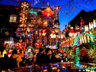 Wisatawan melihat sebuah rumah yang dihiasi lampu Natal di lingkungan Dyker Heights, Brooklyn, New York, Amerika Serikat, 21 Desember 2022. Satu kawasan di Brooklyn, Kota New York, memukau pengunjung dengan lampu hias Natal yang spektakuler. (AP Photo/Julia Nikhinson)