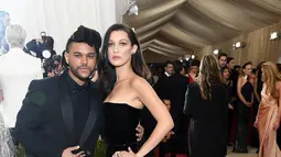 Model Bella Hadid ditemani sang kekasih, The Weeknd tiba di ajang Met Gala 2016 di Metropolitan Museum of Art, New York City, Senin (2/5). Keduanya tampil senada mengenakan warna hitam. (Larry Busacca/GETTY IMAGES NORTH AMERICA/AFP)