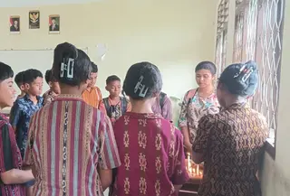 Guru dan teman kelas STN menyalakan lilin di meja ruangan kelas. (Liputan6.com/Ola Keda)