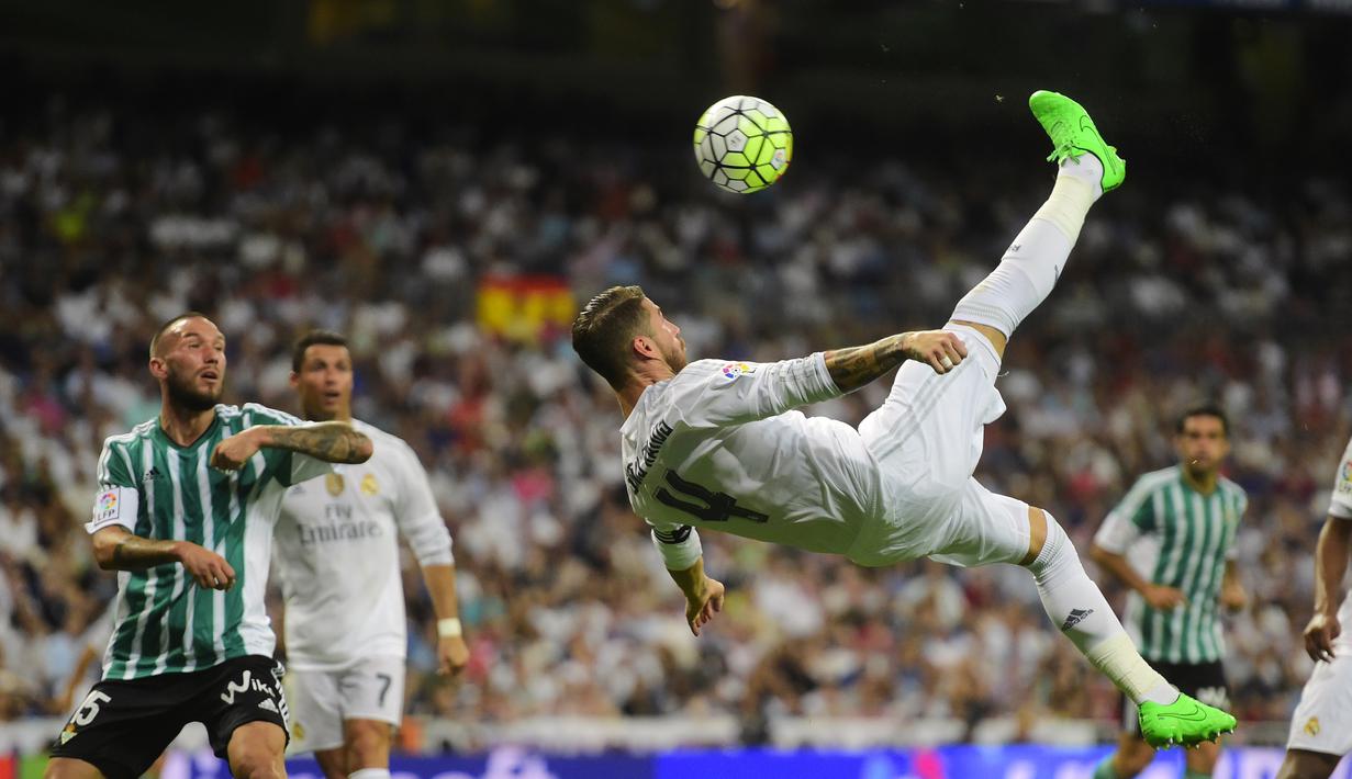 Kapten Real Madrid, Sergio Ramos melakukan tendangan salto saat timnya menang besar 5-0 atas Real Betis Balompie  pada laga La Liga Spanyol di Stadion Santiago Bernabeu, Madrid, (29/8/2015). (AFP Photo/Pierre-Philippe Marcou)