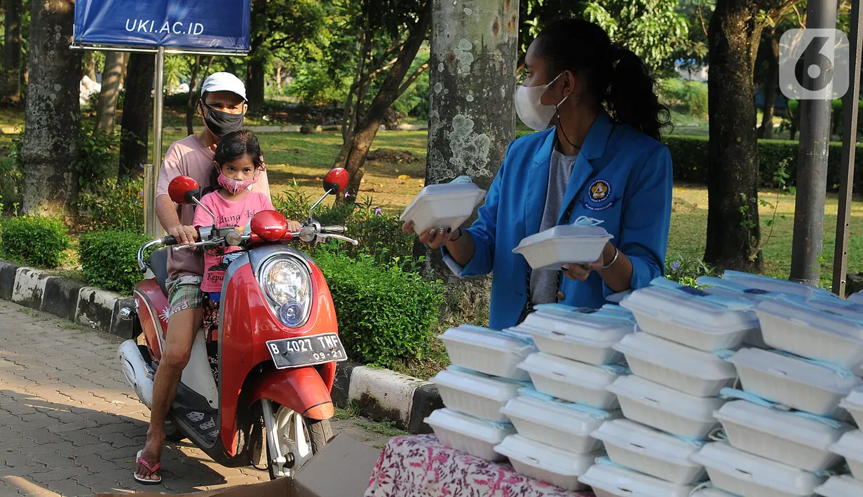 Mahasiswa memberikan makanan gratis kepada masyarakat di UKI, Cawang, Jakarta, Selasa (16/3/2021). Kegiatan ini memberikan 500 bungkus nasi, masker dan vitamin setiap harinya sejak pukul 06.00 WIB, untuk meringankan beban masyarakat di masa pandemi Covid-19. (Liputan6.com/Herman Zakharia)