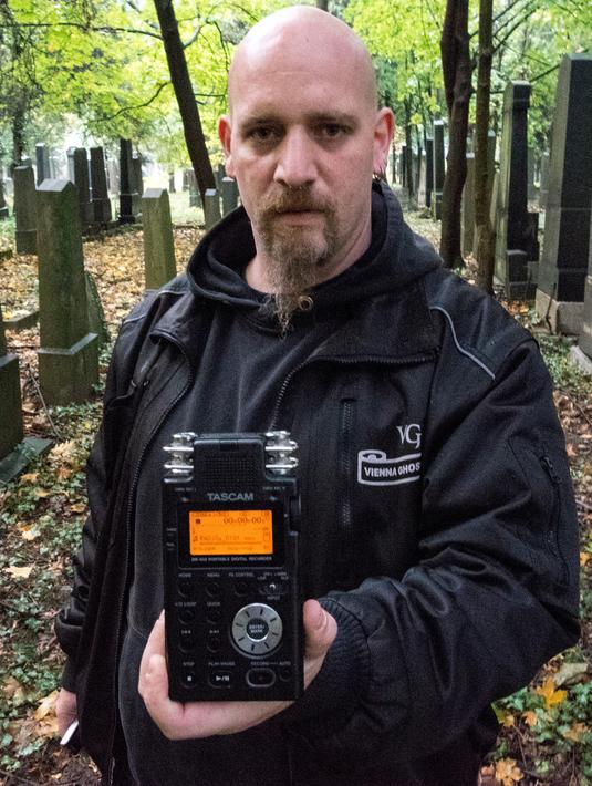 Seorang pemburu hantu menunjukkan alat detektor yang digunakan untuk mencari aktivitas gaib di pusat pemakaman tua di Wina, Austria, 20 Oktober 2016. Pemakaman ini disinyalir memiliki aura mistis yang kental dengan aktivitas makhluk halus (JOE KLAMAR/AFP)