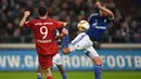 Pemain Bayern Munich Robert Lewandowski (kiri) berebut bola dengan pemain  Schalke 04  Benedikt Hoewedes pada lanjutan Bundesliga di Gelsenkirchen, Jerman,Minggu (22/11/2015) dini hari WIB. Bayern Munich  menang 3-1.   (AFP Photo/Patrik Stollarz)