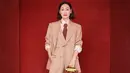 Hui Yinghong tampil dengan mengenakan setelan jas tiga potong, kemeja crepe sutra merah muda, dasi cokelat, sepatu hak tinggi kulit hitam, dan tas Gucci Diana. Sumber: Document/Gucci.