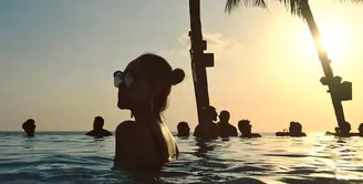 Pada salah satu postingan foto di akun Instagram pribadinya, Bunga Citra Lestari terlihat berpose saat berendam di kolam renang. Foto siluet ini tampak begitu indah. (Foto: instagram.com/bclsinclair)