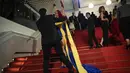 Dalam sebuah aksi nyata untuk mendukung negara yang dilanda perang tersebut, perempuan muda tak dikenal itu menyiram dirinya dengan zat berwarna merah di pemutaran perdana film 'Acide' karya Just Philippot. (AP Photo/Daniel Cole)