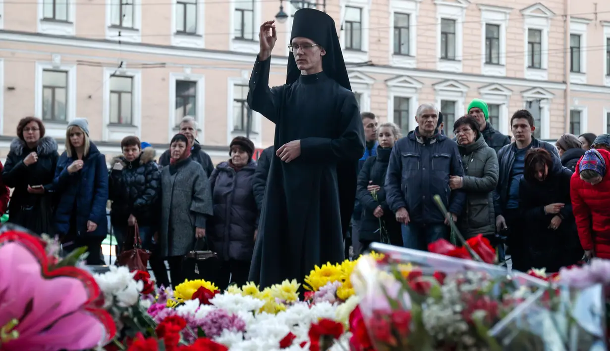 Seorang pendeta memimpin doa saat peringatan simbolik di stasiun kereta bawah tanah Technologicheskiy Institute di St. Petersburg, Rusia, Selasa (4/4). Dikabarkan 10 orang meninggal dalam tragedi tersebut. (AP Photo / Dmitri Lovetsky)