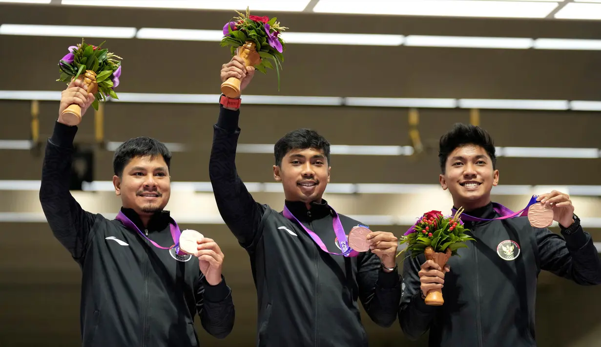 Peraih medali perunggu Indonesia, Irfandi Julio, Muhammad Sejahtera Dwi Putra, tengah, dan Muhammad Badri Akbar (kiri ke kanan) berpose dalam acara penyerahan medali dari cabang olahraga menembak nomor lari 10 meter beregu putra di Fuyang Yinhu Sports Centre pada Asian Games ke-19 di Hangzhou, China, Senin, 25 September 2023. (AP Photo/Aijaz Rahi)