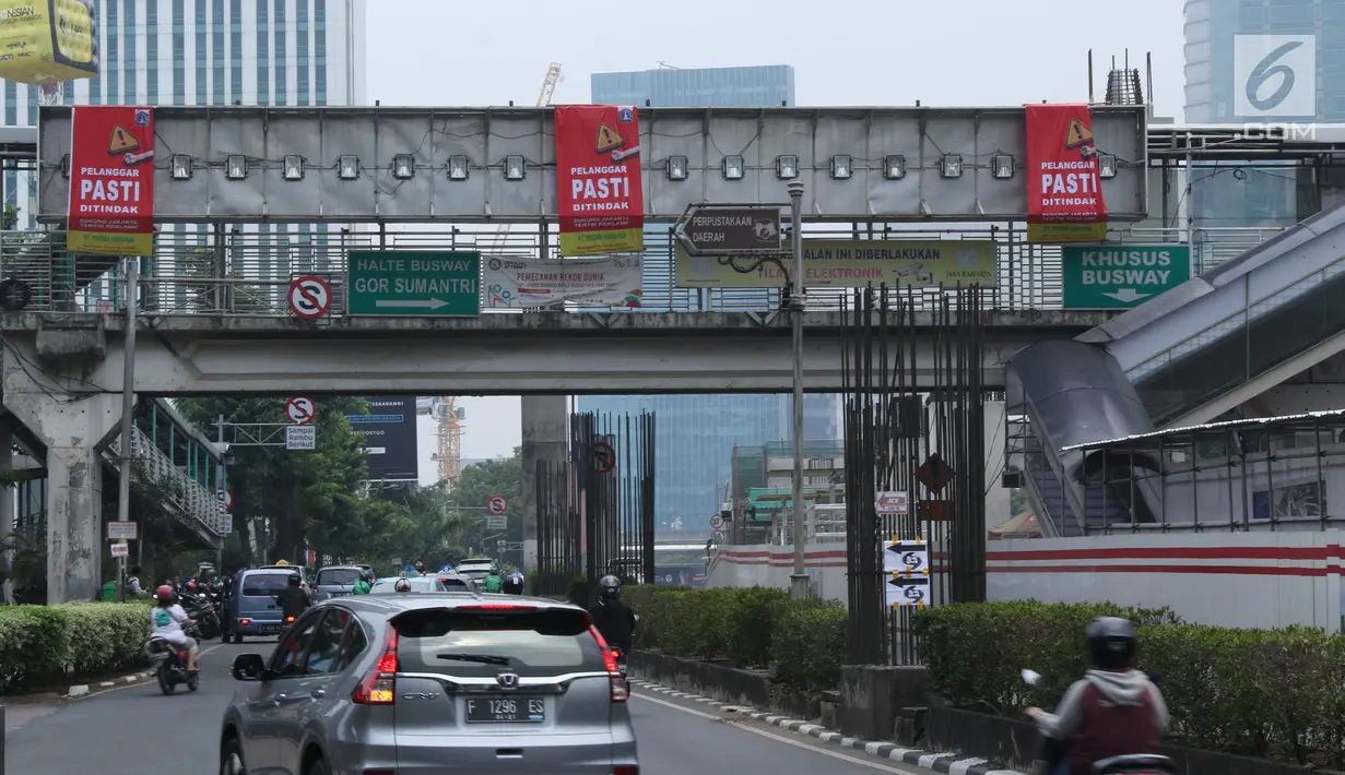 Sejumlah kendaraan melintas di sisi papan reklame di sekitar Jalan HR Rasuna Said, Jakarta, Sabtu (20/12). Ada 60 titik lokasi penyegelan reklame di Jakarta yang akan dilakukan oleh Satpol PP DKI. (Liputan6.com/Helmi Fithriansyah)