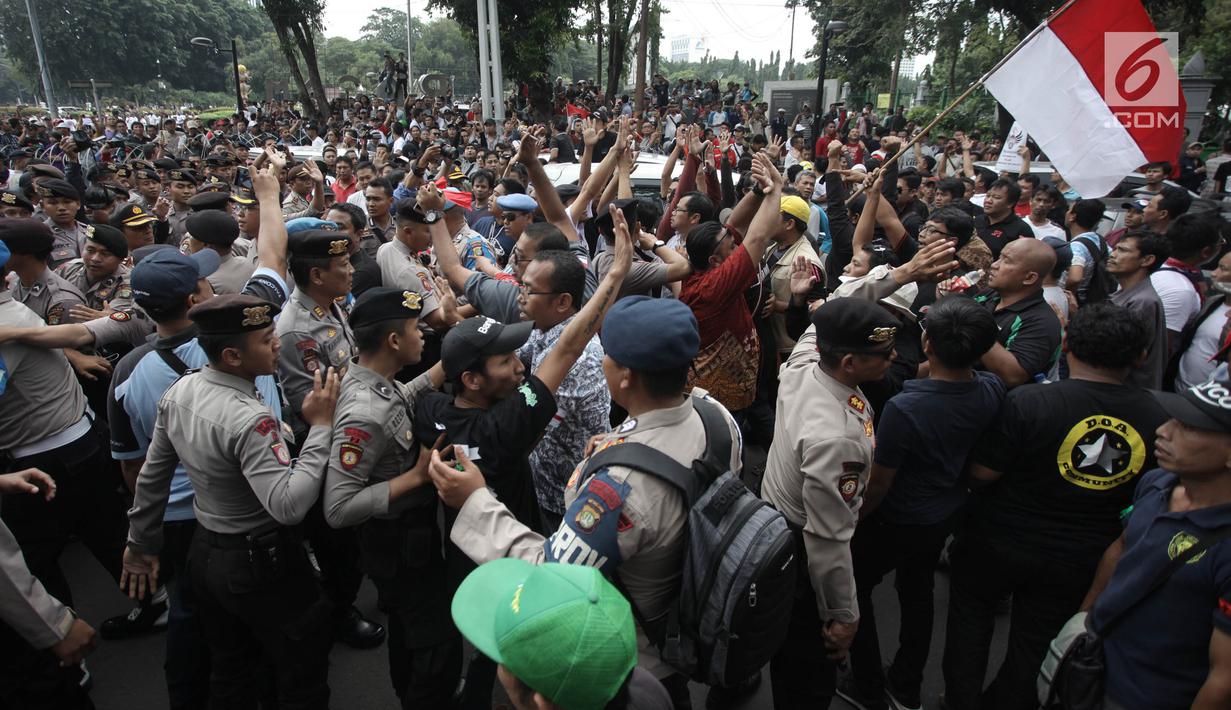 Demonstran driver online saling dorong dengan pihak kepolisian saat unjuk rasa di depan Istana Negara, Jakarta, Rabu (14/2). Kericuhan nyaris terjadi lantaran demonstran mencegat para driver online yang masih beroperasi. (Liputan6.com/Arya Manggala)