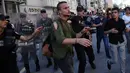 Polisi anti huru hara menahan seorang peserta yang berusaha mengikuti parade Gay Pride di pusat kota Istanbul, Minggu (25/6). Pihak berwenang Turki membatalkan parade gay di Istanbul setelah dilarang selama tiga tahun berturut-turut. (AP/Emrah Gurel)