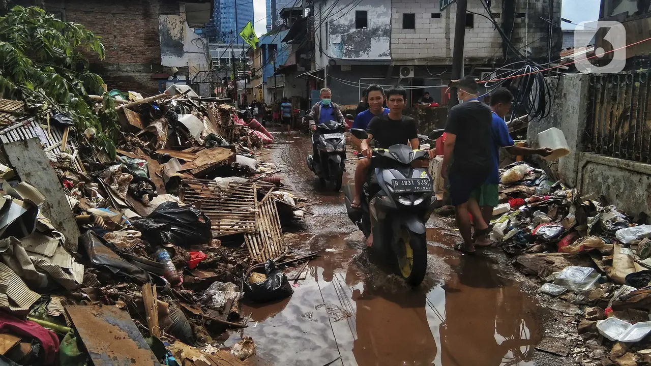 FOTO: Warga Bersihkan Sisa Banjir di Kebalen
