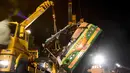 Alat berat mengevakuasi bangkai bus pariwisata Taiwan yang mengalami kecelakaan di ruas jalan dekat Taipe, Selasa (14/2). Kejadian nahas tersebut terjadi saat bus hendak membawa 44 turis berwisata melihat keindahan bunga sakura. (Ou Dongqu/Xinhua via AP)
