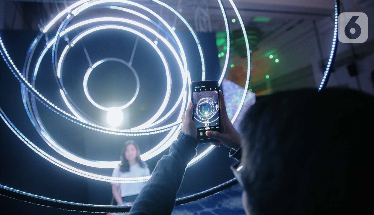 Pengunjung berpose saat mengunjungi pameran seni berbasis teknologi berwujud sorotan cahaya futuristik 'Wave of Tomorrow' di Jakarta, Sabtu (21/12/2019). Di mana karya seni tersebut menyoroti yang terjadi di masa kini dan memprediksi apa yang akan terjadi di masa depan. (Liputan6.com/Faizal Fanani)