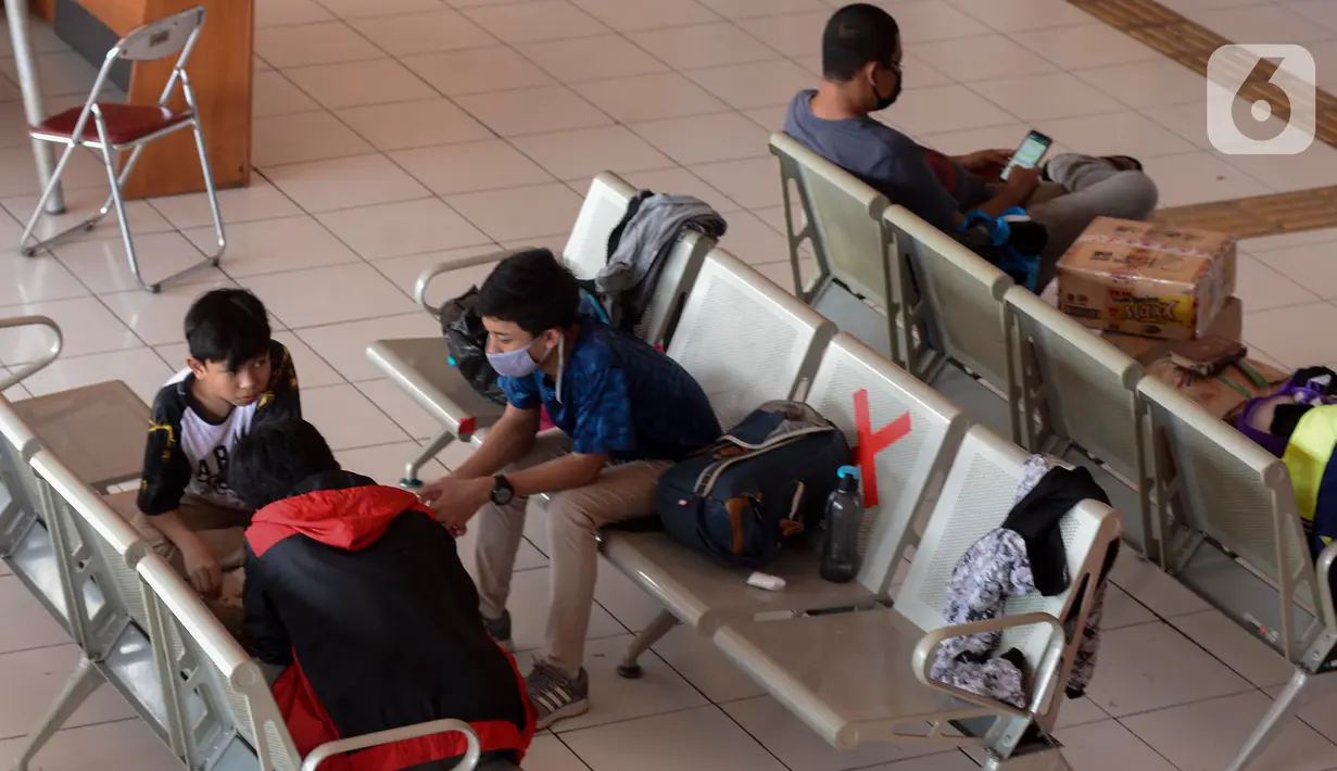 Sejumlah calon pemudik menanti kedatangan bus di Terminal Kampung Rambutan, Jakarta, Rabu (22/4/2020). Terminal Kampung Rambutan masih melayani penumpang menjelang pelarangan mudik Lebaran 2020 guna memutus mata rantai penyebaran COVID-19 pada Jumat 24 April mendatang. (merdeka.com/Imam Buhori)