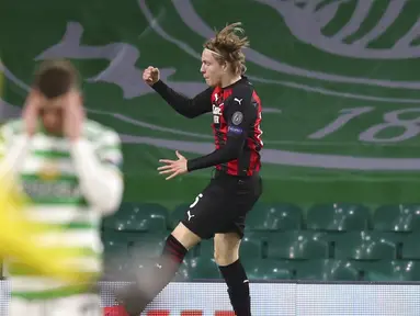 Pemain AC Milan Jens Petter Hauge melompat untuk merayakan gol ketiga timnya saat menghadapi Celtic pada pertandingan leg pertama Grup H Liga Europa di Celtic Park, Glasgow, Skotlandia, Kamis (22/10/2020). AC Milan menang 3-1. (Jane Barlow/Pool via AP)