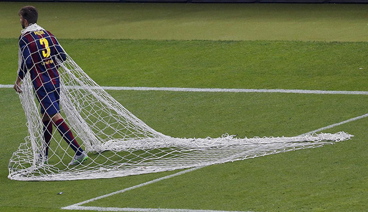 Gerard Pique bek Barcelona memotong jala gawang usai final Liga Champions melawan Juventus  di Olympiastadion, Berlin. (REUTERS Michael Dalder)
