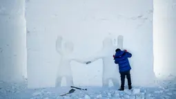 Seorang seniman mengukir patung es raksasa simbol persahabatan di Snow Land, PyeongChang, Korea Selatan, Senin (5/2). (Brendan Smialowski/AFP)