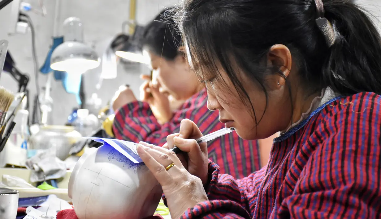Sejumlah pekerja menggambar pola pada perkakas emas dan perak di sebuah bengkel kerja di Kota Baimasi di Distrik Luolong, Luoyang, Provinsi Henan, China tengah (11/11/2020). (Xinhua/Han Chaoyang)