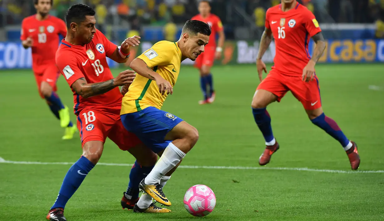 Gelandang Brasil, Philippe Coutinho, berusaha melewati bek Cile, Gonzalo Jara, pada laga kualifikasi Piala Dunia 2018 di Stadion Allianz Parque, Sao Paulo, Selasa (10/10/2017). Brasil menang 3-0 atas Cile. (AFP/Nelson Almeida)