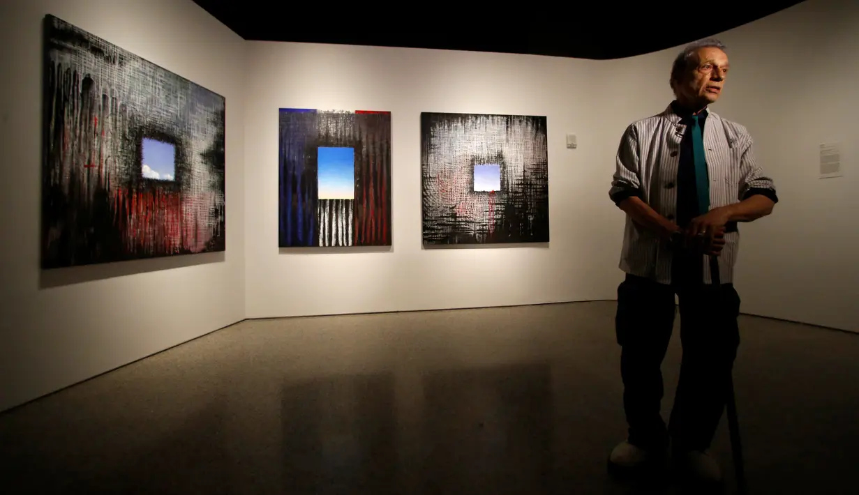Seniman Ejay Weiss berdiri di depan karya lukisnya berjudul '9/11 Elegies' yang dipamerkan di National September 11 Memorial and Museum, Manhattan, AS (1/9). Pameran ini diikuti oleh 13 seniman asal New York. (REUTERS/Andrew Kelly)