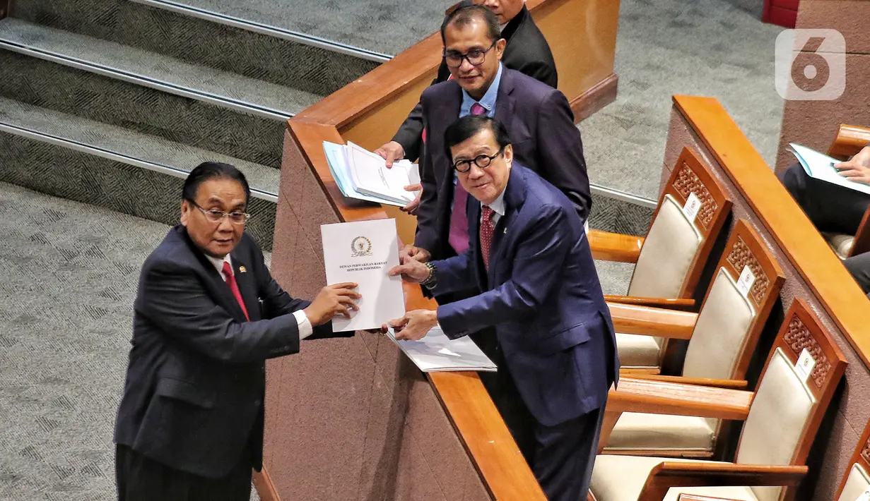 Ketua Komisi III DPR Bambang Wuryanto saat memberikan dokumen laporan Komisi III kepada Menteri Hukum dan HAM Yasonna Laoly saat rapat paripurna DPR di Jakarta, Selasa (6/12/2022). DPR RI resmi mengesahkan Rancangan Undang-Undang Kitab Undang-Undang Hukum Pidana (RUU KUHP) menjadi Undang-Undang. (Liputan6.com/Angga Yuniar)