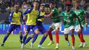 Pemain Al Nassr, Cristiano Ronaldo (kedua kiri) berusaha menyambut bola hasil tendangan pojok saat laga lanjutan Liga Pro Arab Saudi 2022/2023 melawan Al Ettifaq yang berlangsung di Mrsool Park, Riyadh, Arab Saudi, Minggu (22/01/2023). Al Nassr berhasil menang dengan skor 1-0 dan kini menempati puncak klasemen sementara Liga Pro Arab Saudi 2022/2023. (AFP/Fayez Nureldine)
