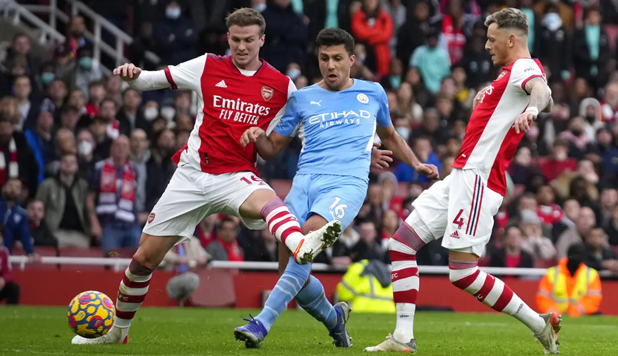 Pemain Manchester City Rodrigo (tengah) menendang untuk mencetak gol melewati pemain Arsenal Rob Holding (kiri) dan Ben White pada pertandingan sepak bola Liga Inggris di Stadion Emirates, London, Inggris, 1 Januari 2022. Manchester City menang 2-1. (AP Photo/Matt Dunham)